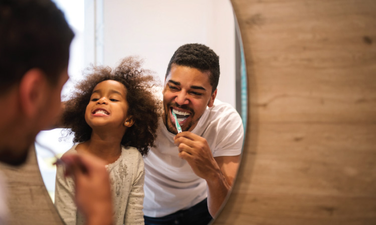 Father and daughter brushing teeth before bedtime